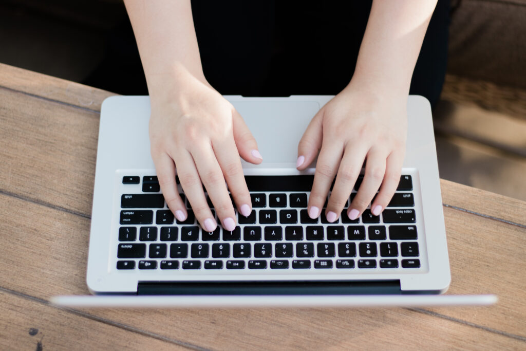 Photo of hands typing on a laptop.