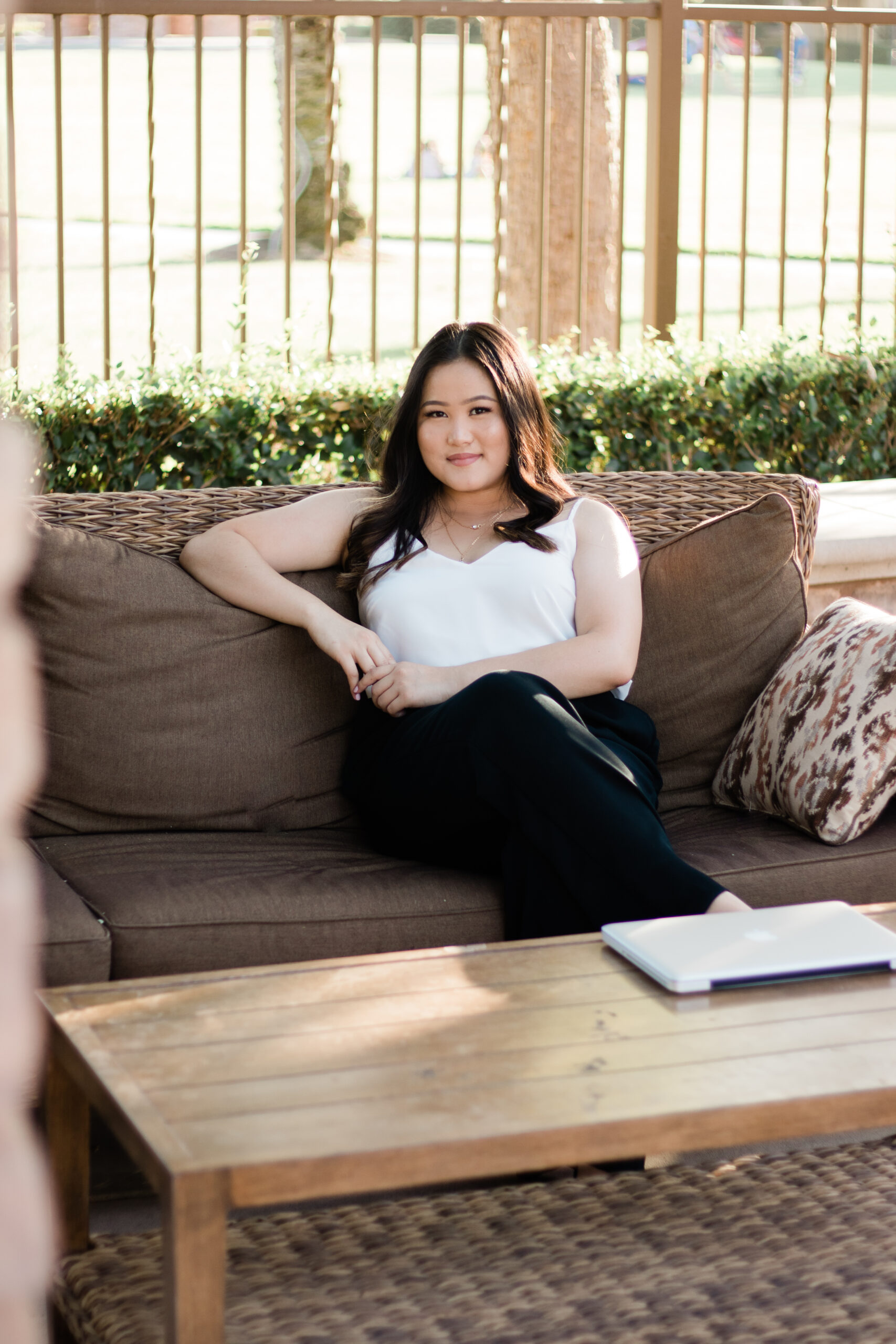 Photo of Karey Cha sitting on a couch outdoors.